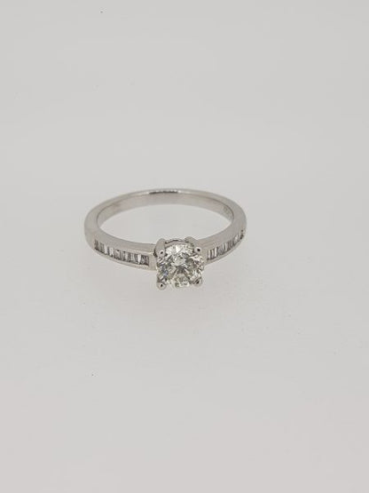 Diamond Solitaire Engagement Ring with Princess Cut Diamond Shoulders; central 0.85ct round brilliant-cut diamond, claw-set, flanked by 0.42cts channel-set princess-cut diamond set shoulders, in 18ct white gold