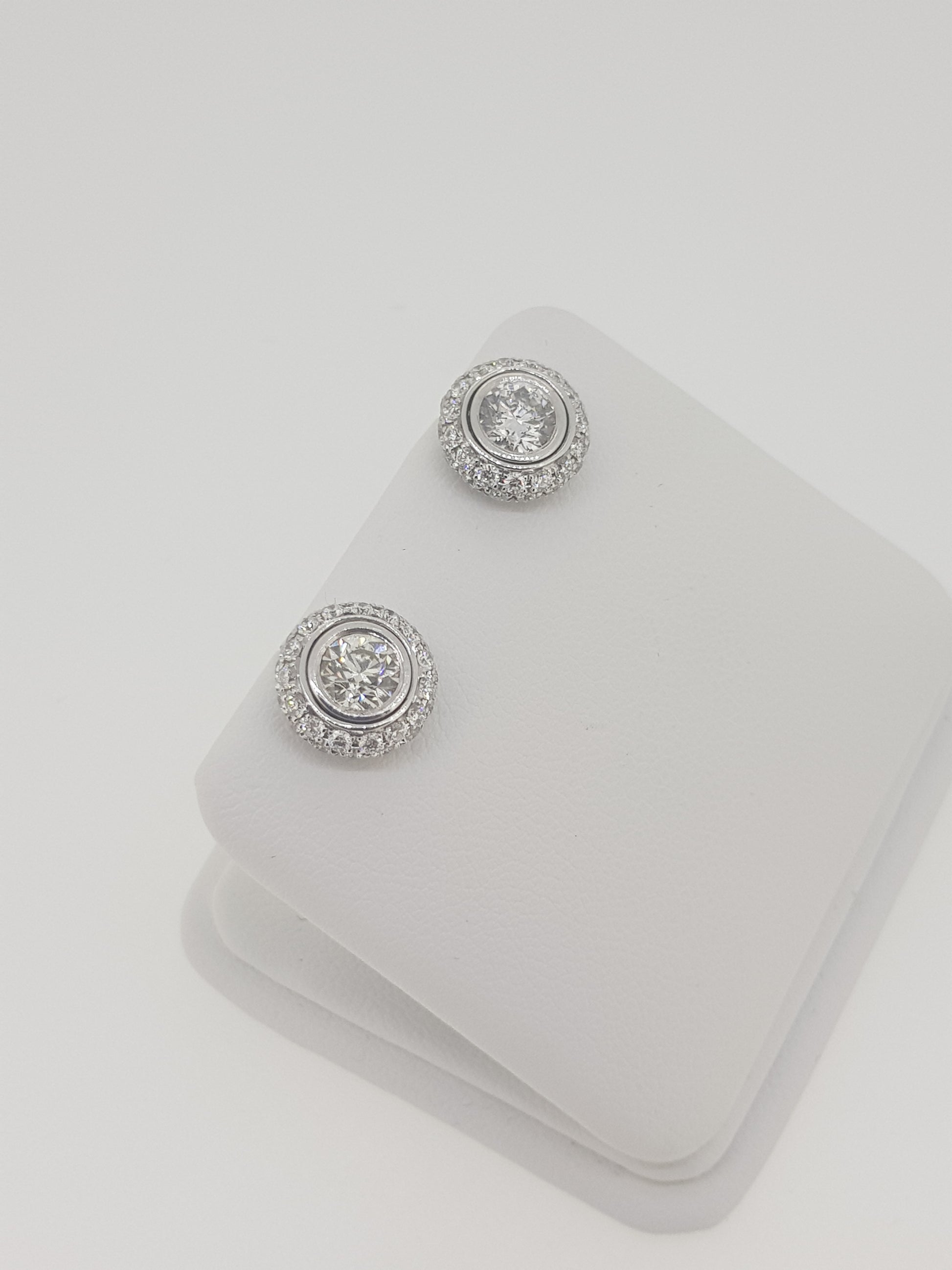 A pair of diamond round cluster earrings in white gold