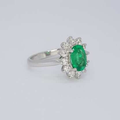1.38ct Emerald and Diamond Oval Cluster Ring; central 1.38 carat oval emerald surrounded by twelve brilliant cut diamonds, in 18ct white gold