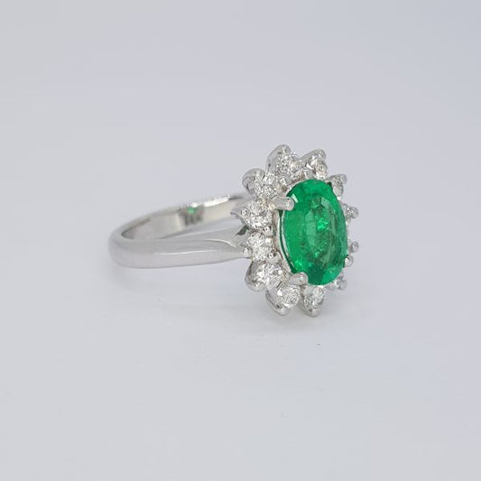1.38ct Emerald and Diamond Oval Cluster Ring; central 1.38 carat oval emerald surrounded by twelve brilliant cut diamonds, in 18ct white gold