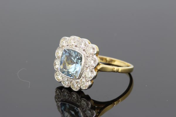 Aquamarine and Diamond Floral Cluster Ring; central 1.35ct square cushion-shaped aquamarine surrounded by 1.25cts diamonds, in 18ct gold