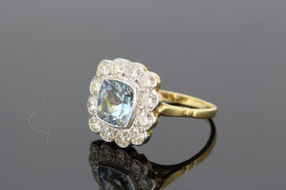 Aquamarine and Diamond Floral Cluster Ring; central 1.35ct square cushion-shaped aquamarine surrounded by 1.25cts diamonds, in 18ct gold