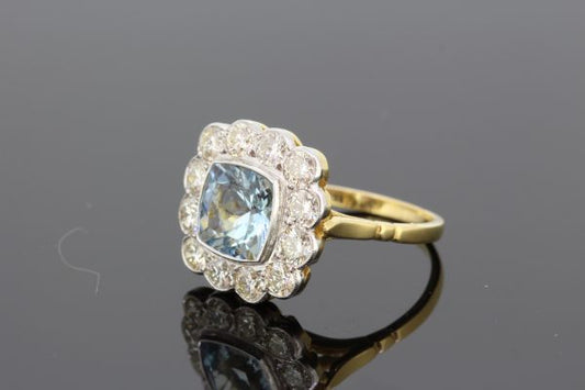 Aquamarine and Diamond Floral Cluster Ring; central 1.35ct square cushion-shaped aquamarine surrounded by 1.25cts diamonds, in 18ct gold