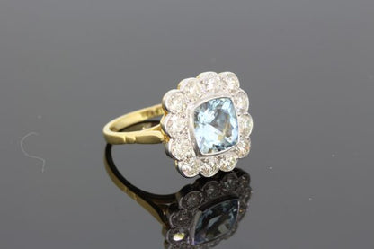 Aquamarine and Diamond Floral Cluster Ring; central 1.35ct square cushion-shaped aquamarine surrounded by 1.25cts diamonds, in 18ct gold