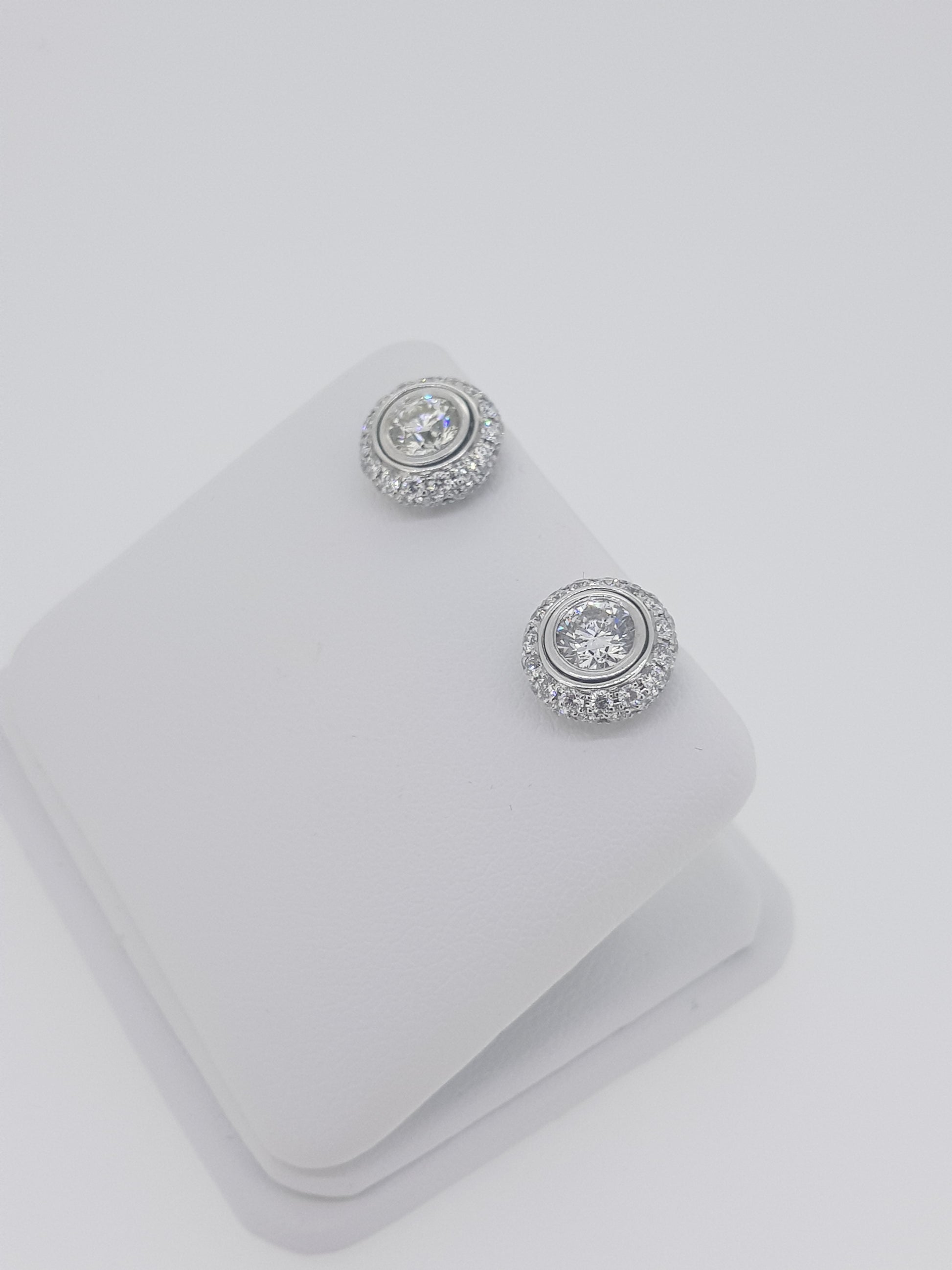 A pair of diamond round cluster earrings in white gold