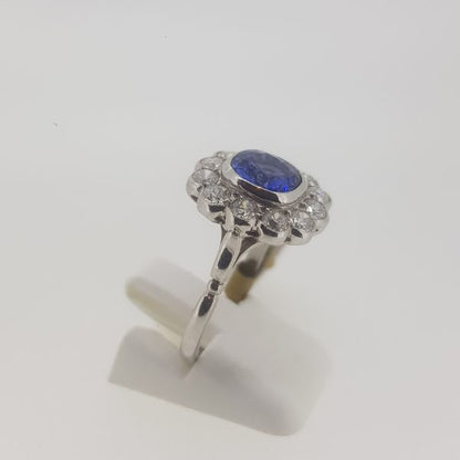 Sapphire and Diamond Floral Cluster Ring; central sapphire surrounded by diamonds, all collet set and mounted in 18ct white gold