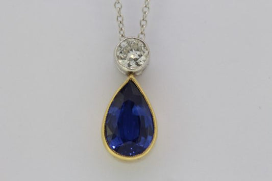 Pear Cut Sapphire and Diamond Drop Pendant; featuring a 1.77ct pear-cut sapphire in yellow gold suspended from a 0.25ct round brilliant-cut diamond in white gold