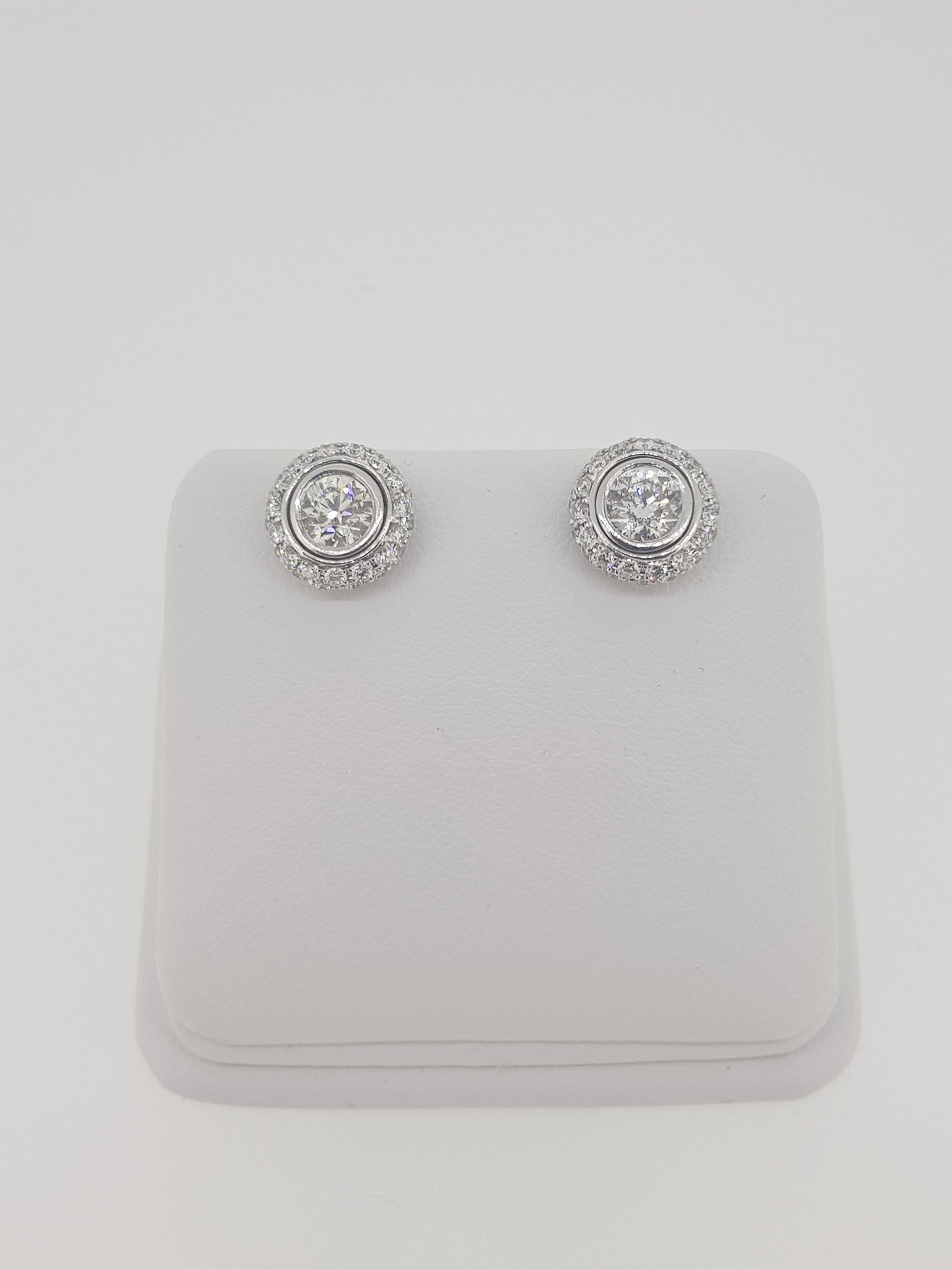 A pair of diamond round cluster earrings in white gold