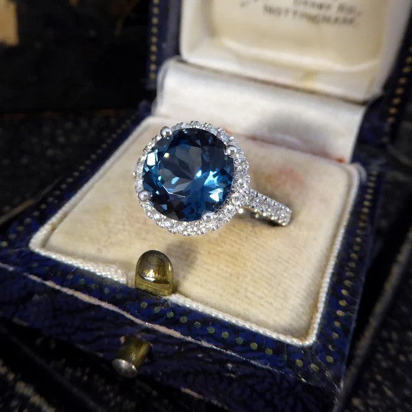 Halo cluster ring with London blue topaz and diamonds set in platinum.
