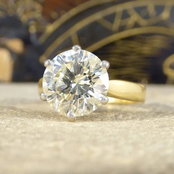 Solitaire diamond engagement ring in white and yellow gold.