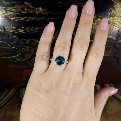 Halo cluster ring with London blue topaz and diamonds set in platinum.