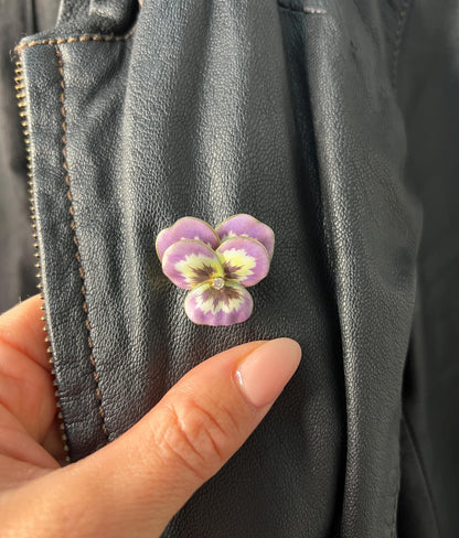 An enamelled pansy flower pendant/brooch with a diamond centre, in yellow gold, modelled on a black jacket