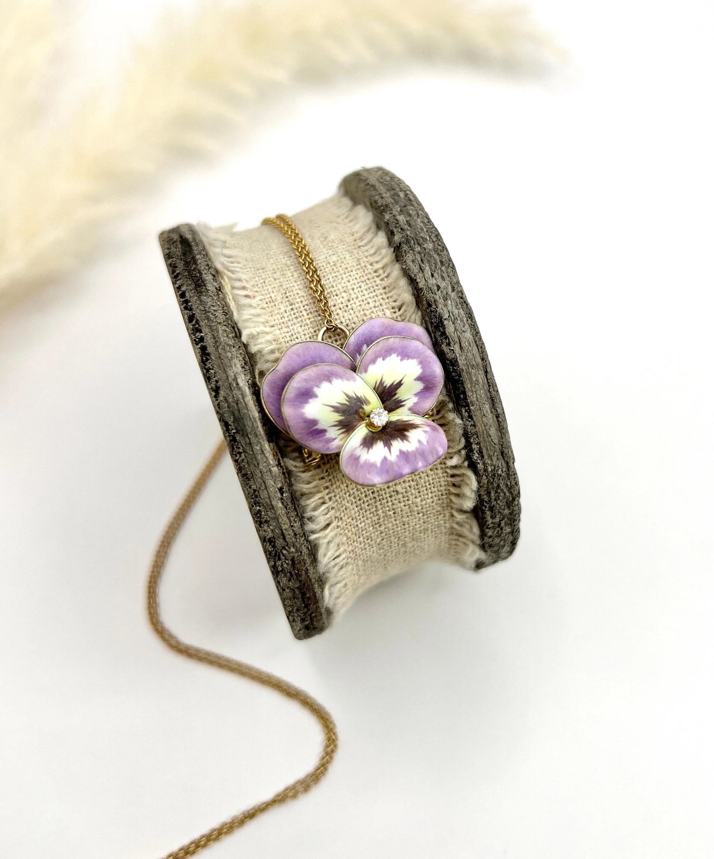 An enamelled pansy flower pendant/brooch with a diamond centre, in yellow gold, with a chain