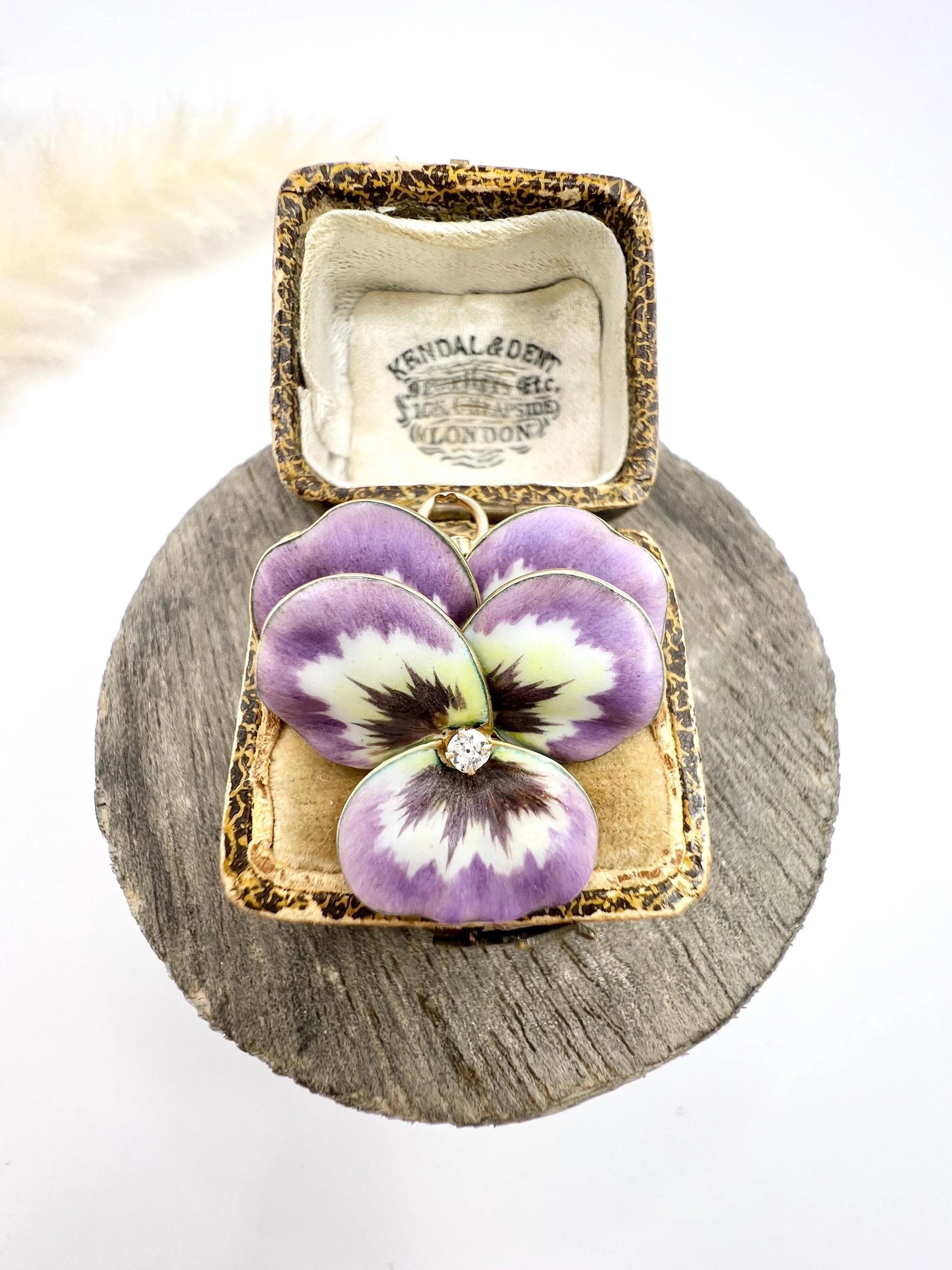 An enamelled pansy flower pendant/brooch with a diamond centre, in yellow gold