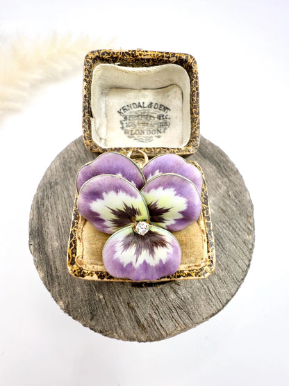 An enamelled pansy flower pendant/brooch with a diamond centre, in yellow gold