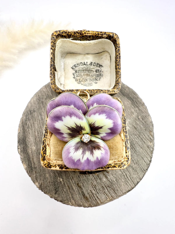 An enamelled pansy flower pendant/brooch with a diamond centre, in yellow gold