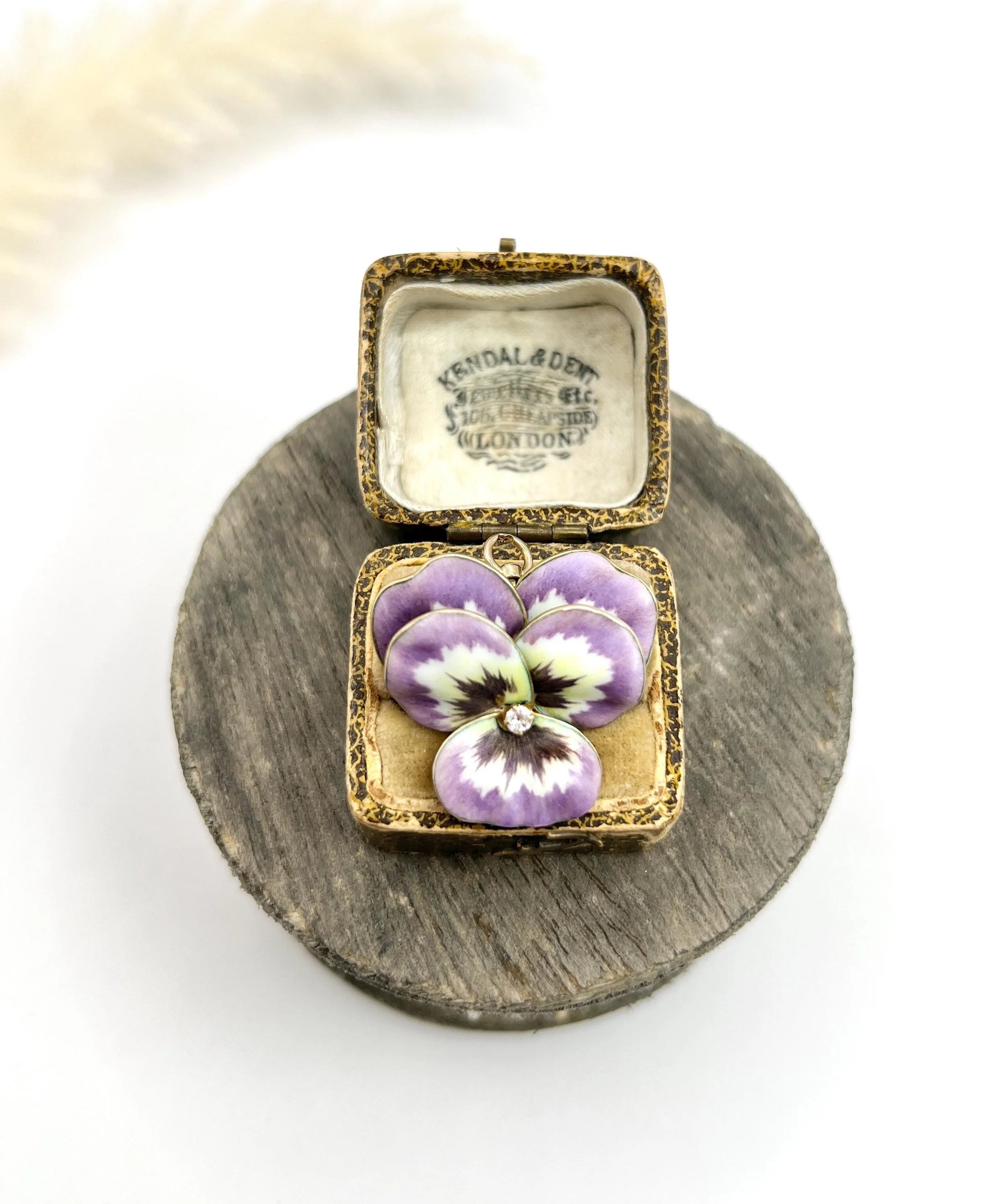 An enamelled pansy flower pendant/brooch with a diamond centre, in yellow gold
