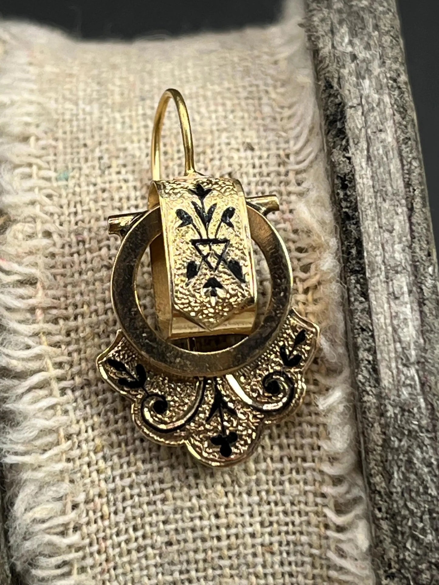 A yellow gold and black enamel drop earring