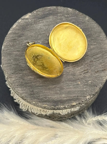 A yellow gold oval patterned locket pendant, open