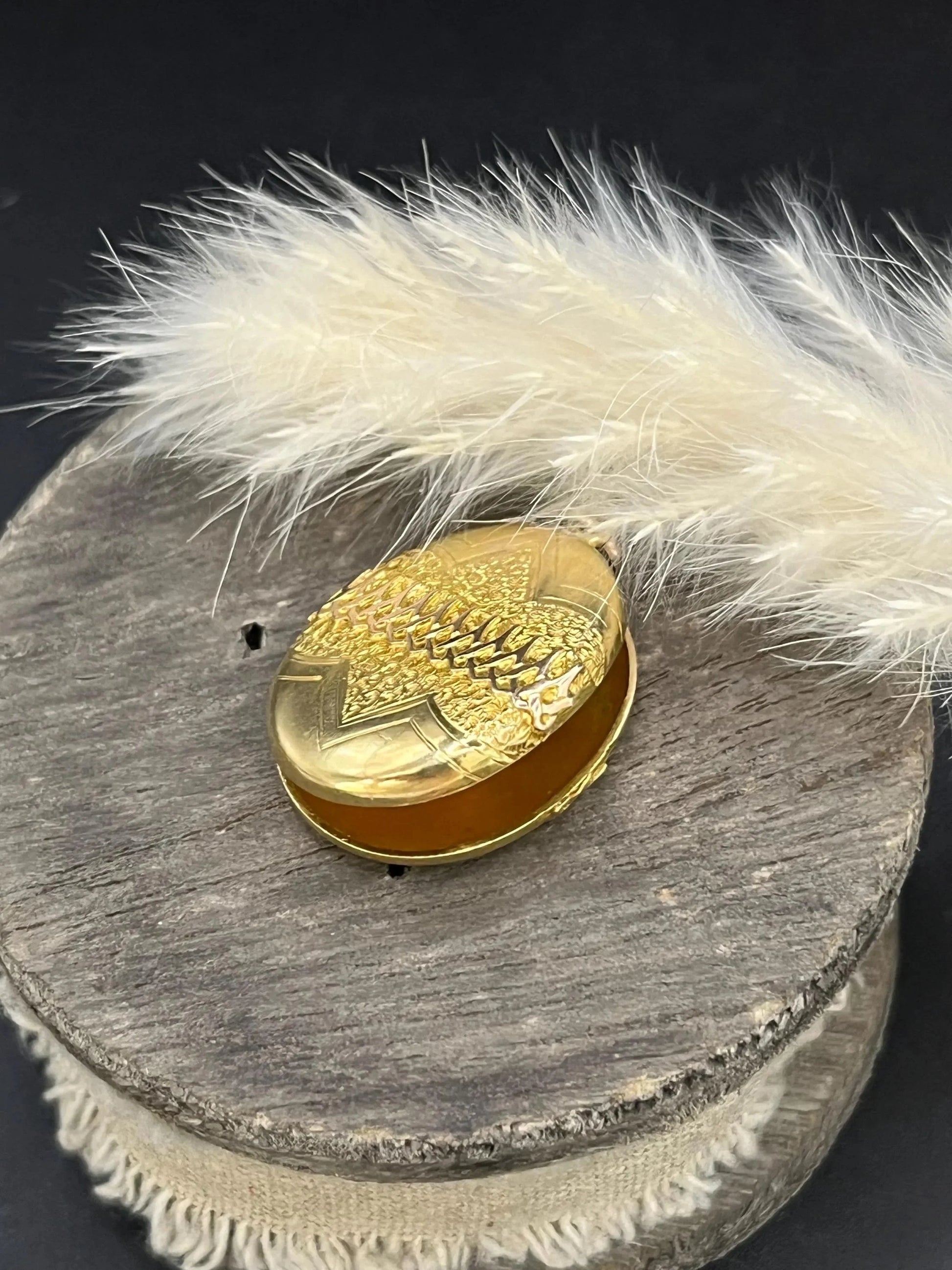 A yellow gold oval patterned locket pendant