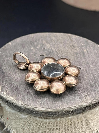 An antique garnet locket pendant in gold