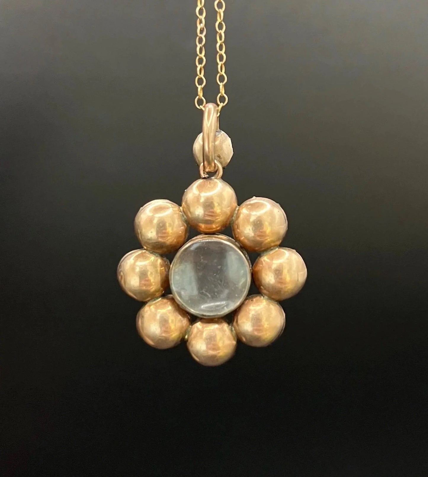 An antique garnet locket pendant in gold, with a chain