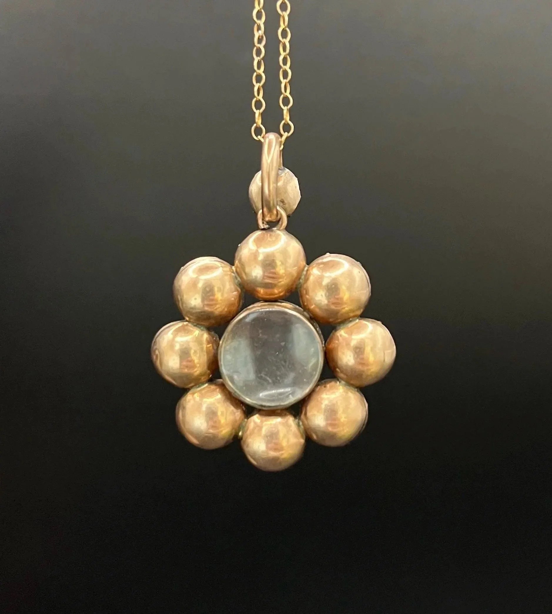 An antique garnet locket pendant in gold, with a chain