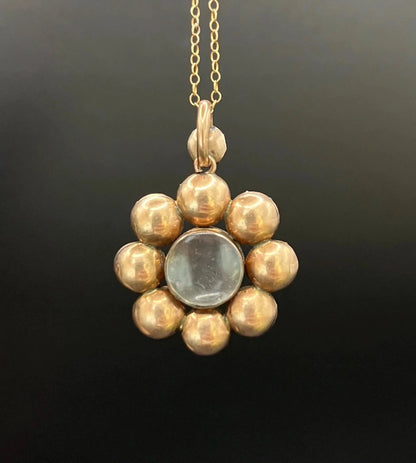 An antique garnet locket pendant in gold, with a chain