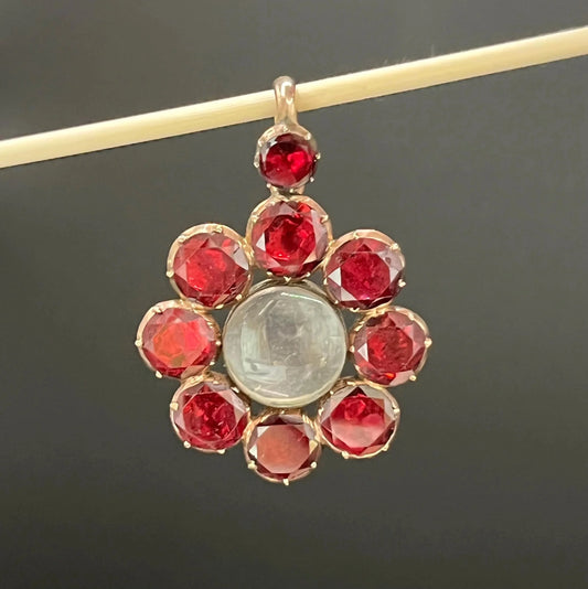 An antique garnet locket pendant in gold