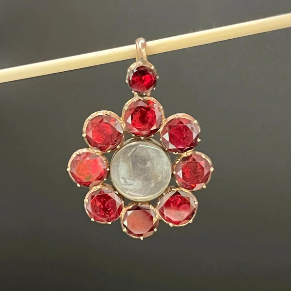 An antique garnet locket pendant in gold