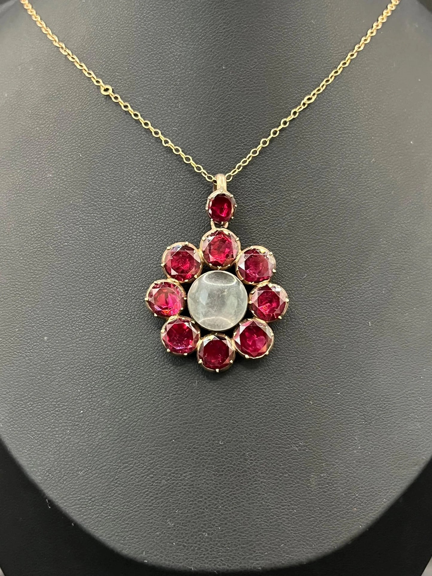 An antique garnet locket pendant in gold, with a chain