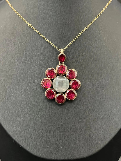 An antique garnet locket pendant in gold, with a chain