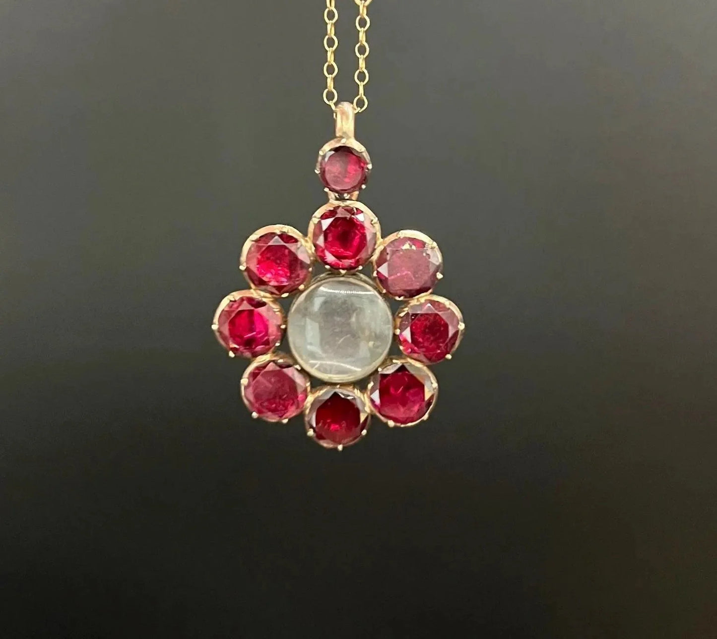 An antique garnet locket pendant in gold, with a chain