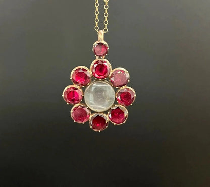 An antique garnet locket pendant in gold, with a chain