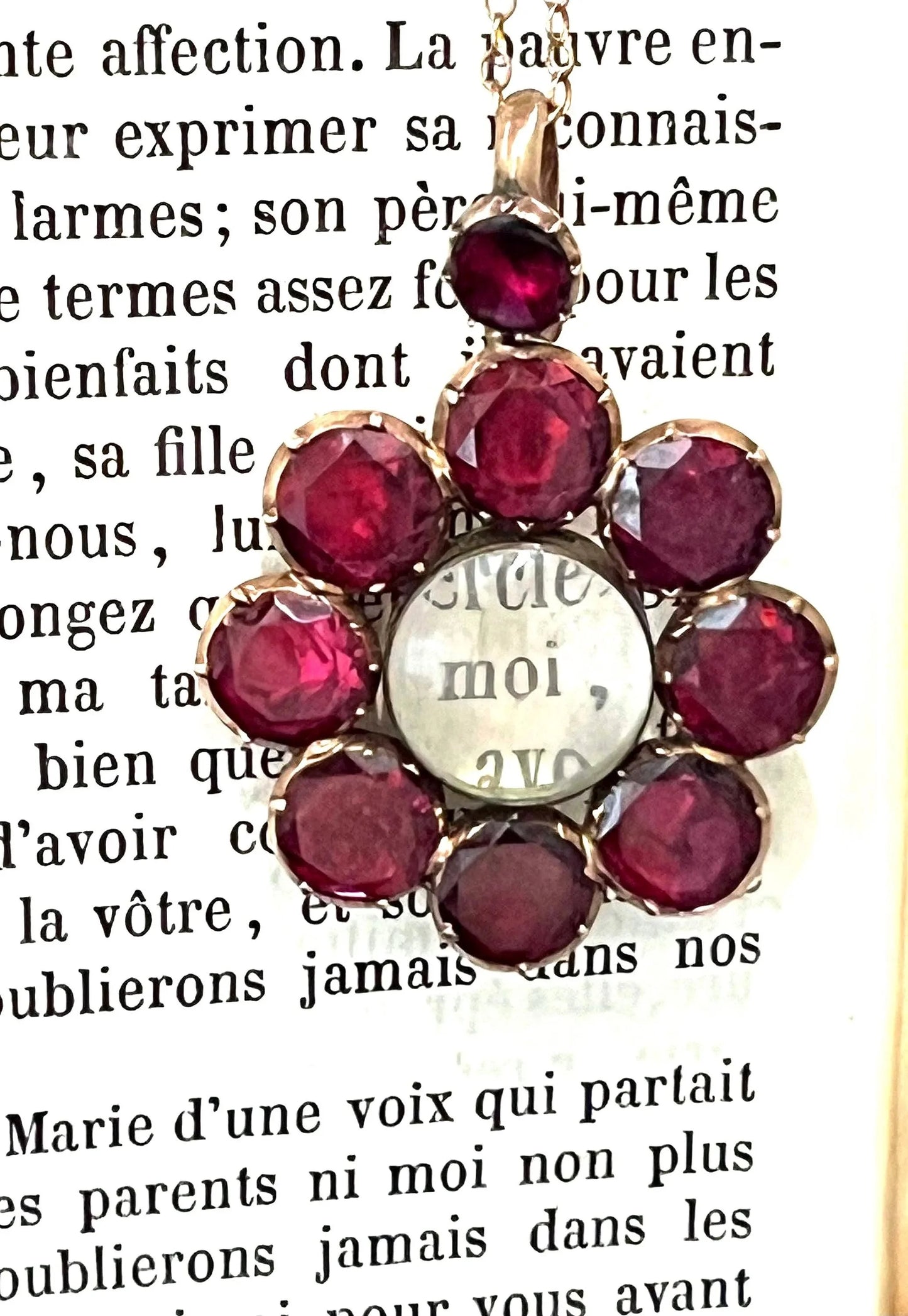 An antique garnet locket pendant in gold, with a chain