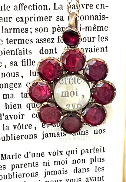 An antique garnet locket pendant in gold, with a chain