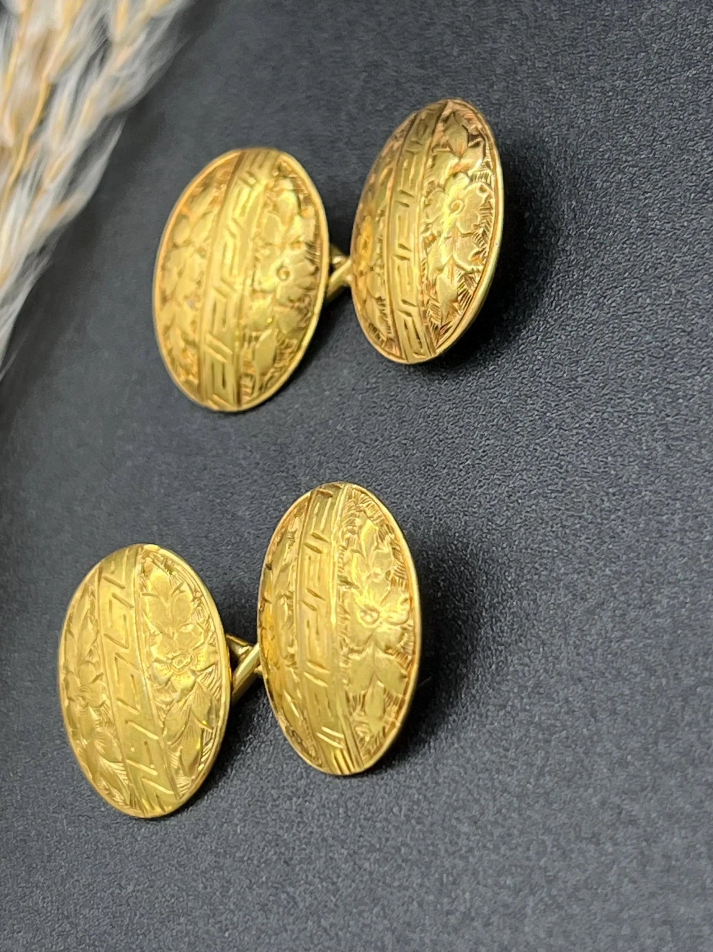A pair of oval yellow gold floral engraved cufflinks