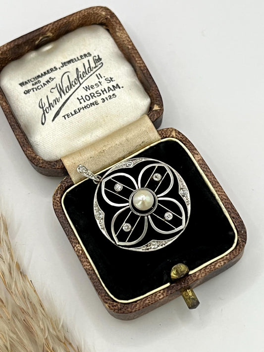 A circular openwork pendant with a pearl and diamonds, in yellow gold and platinum