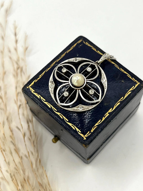 A circular openwork pendant with a pearl and diamonds, in yellow gold and platinum