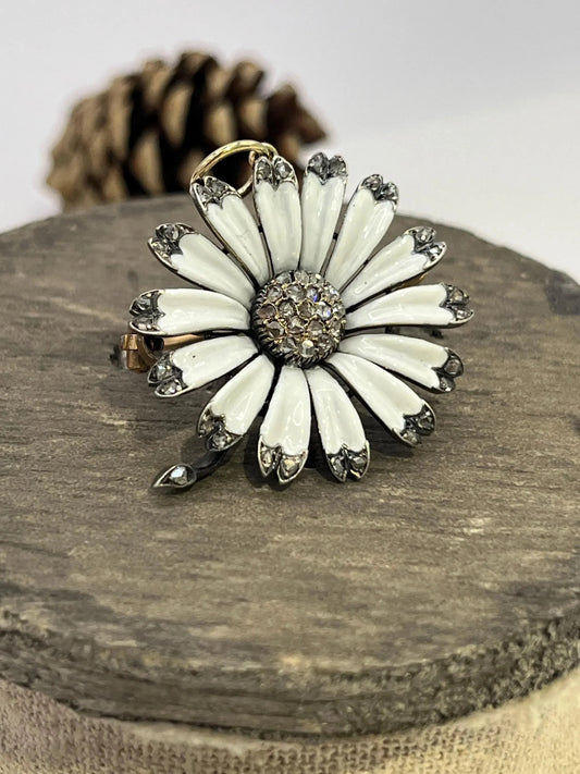 A white enamel and diamond flower pendant-brooch, on a wooden spool