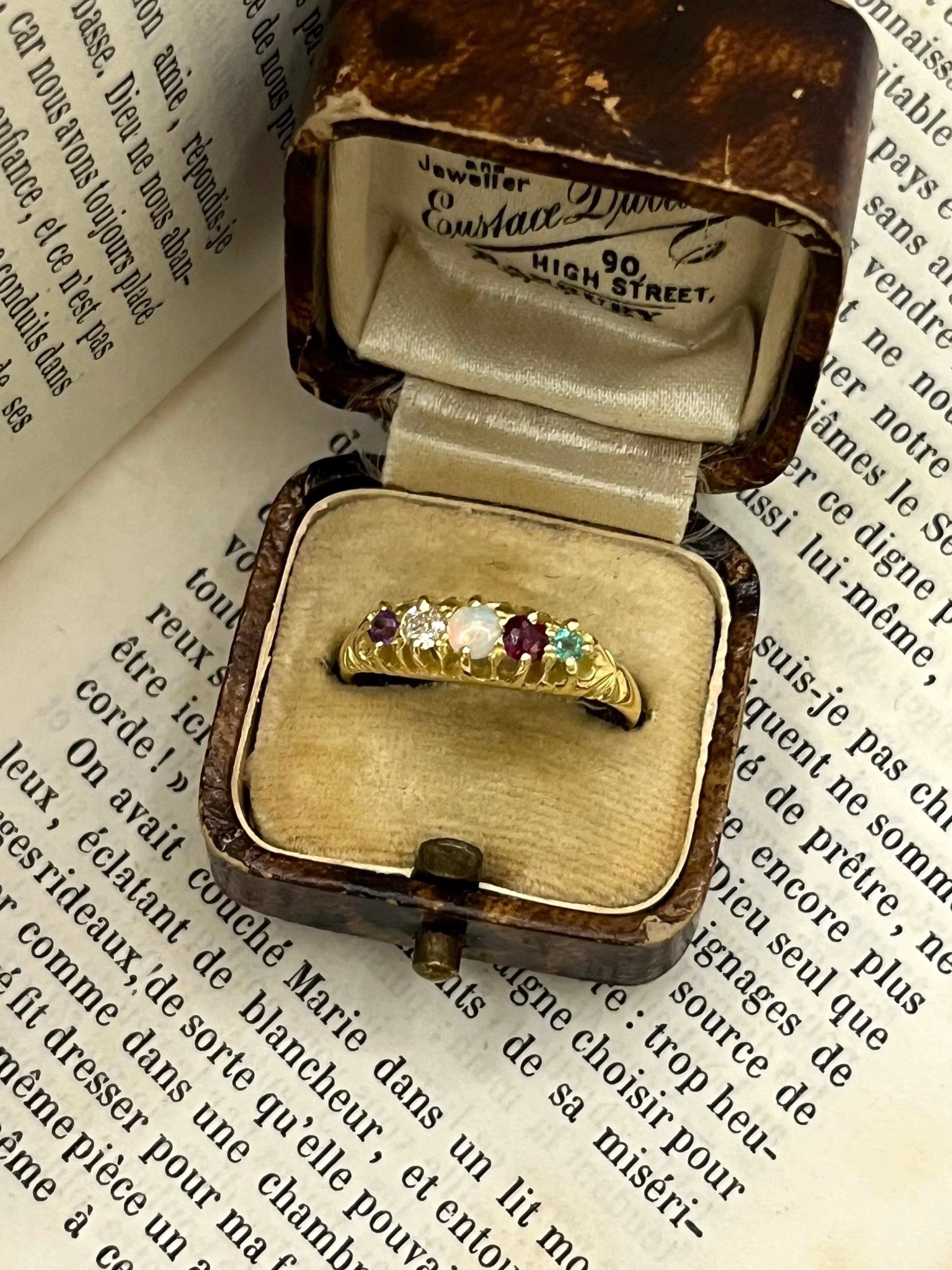 A yellow gold five stone acrostic multi-gemstone ring, in an antique ring box