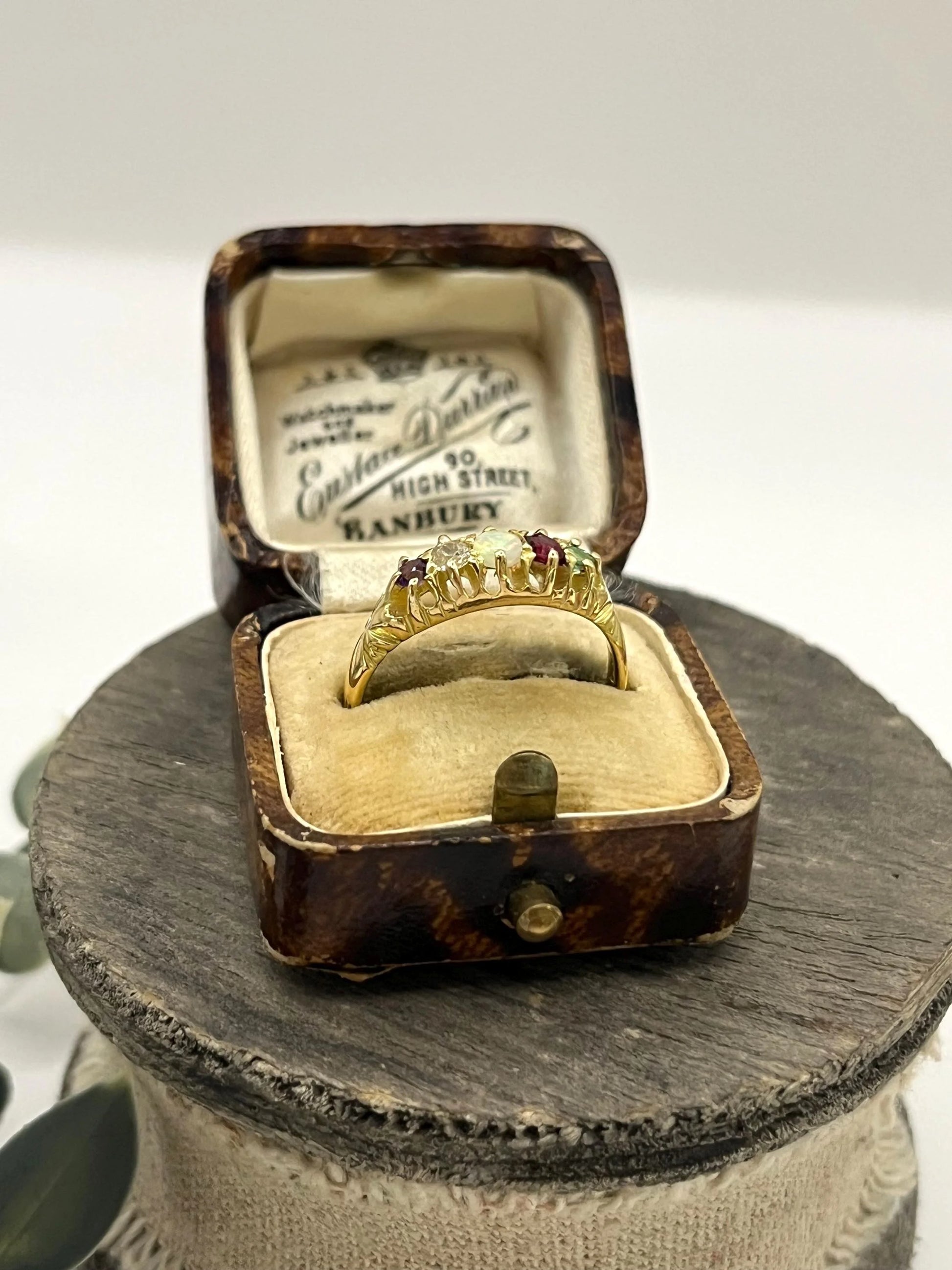 A yellow gold five stone acrostic multi-gemstone ring, in an antique ring box