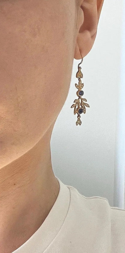 A sapphire and diamond foliate drop earring in yellow gold, modelled in an ear