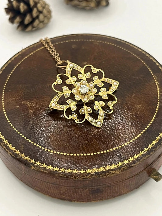 A yellow gold seed pearl and diamond floral pendant brooch, with a chain