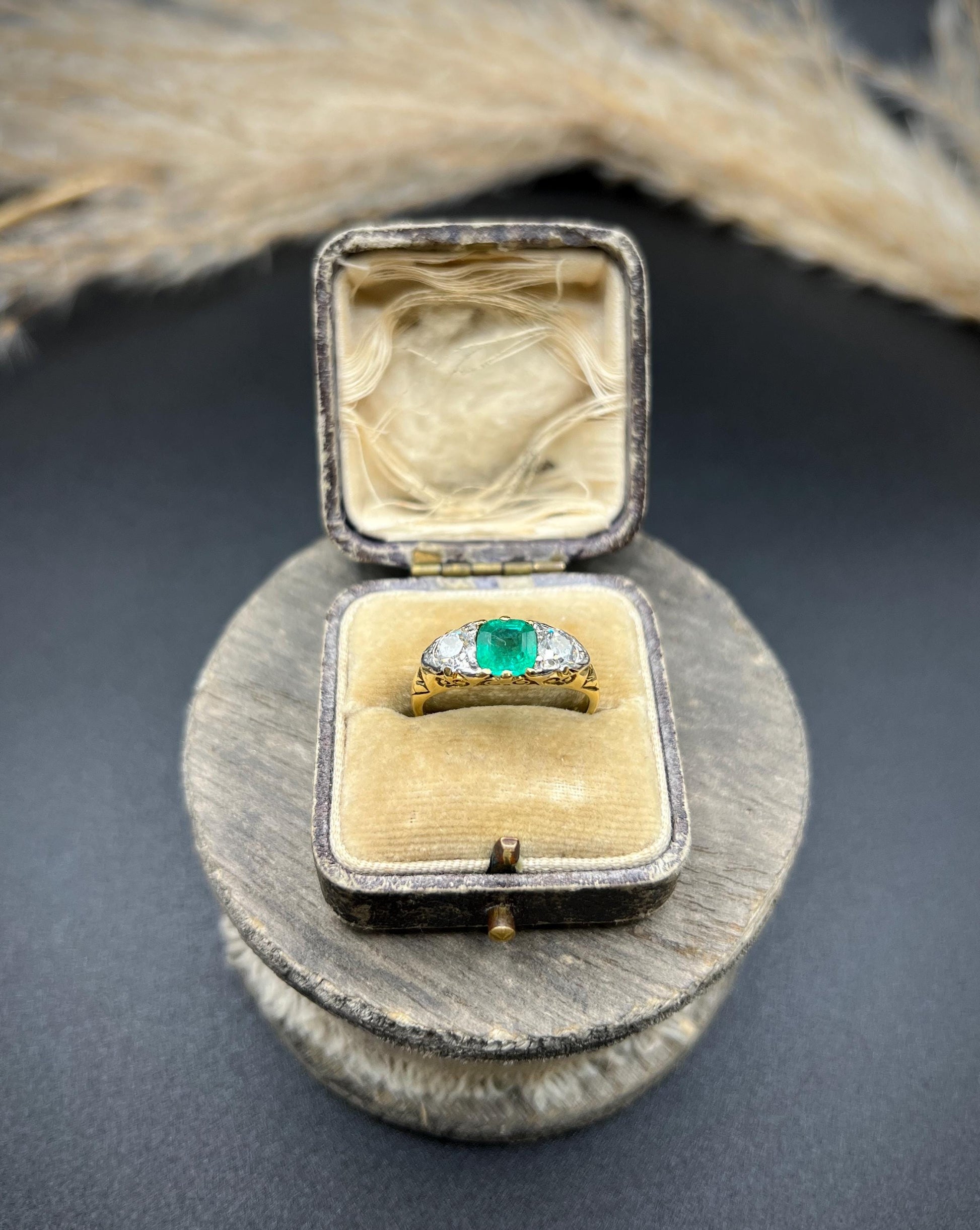 A three stone old cut emerald and diamond ring in yellow gold, in a ring box