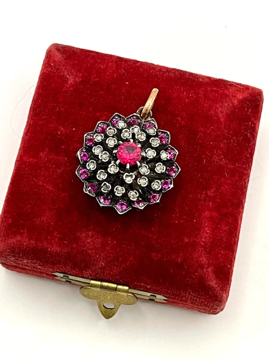 A synthetic ruby and diamond floral cluster pendant in gold and silver