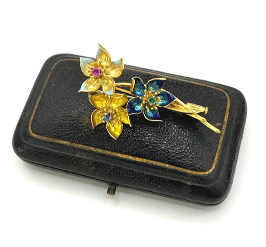 A yellow gold flower brooch with enamel, sapphire, ruby and emerald centres