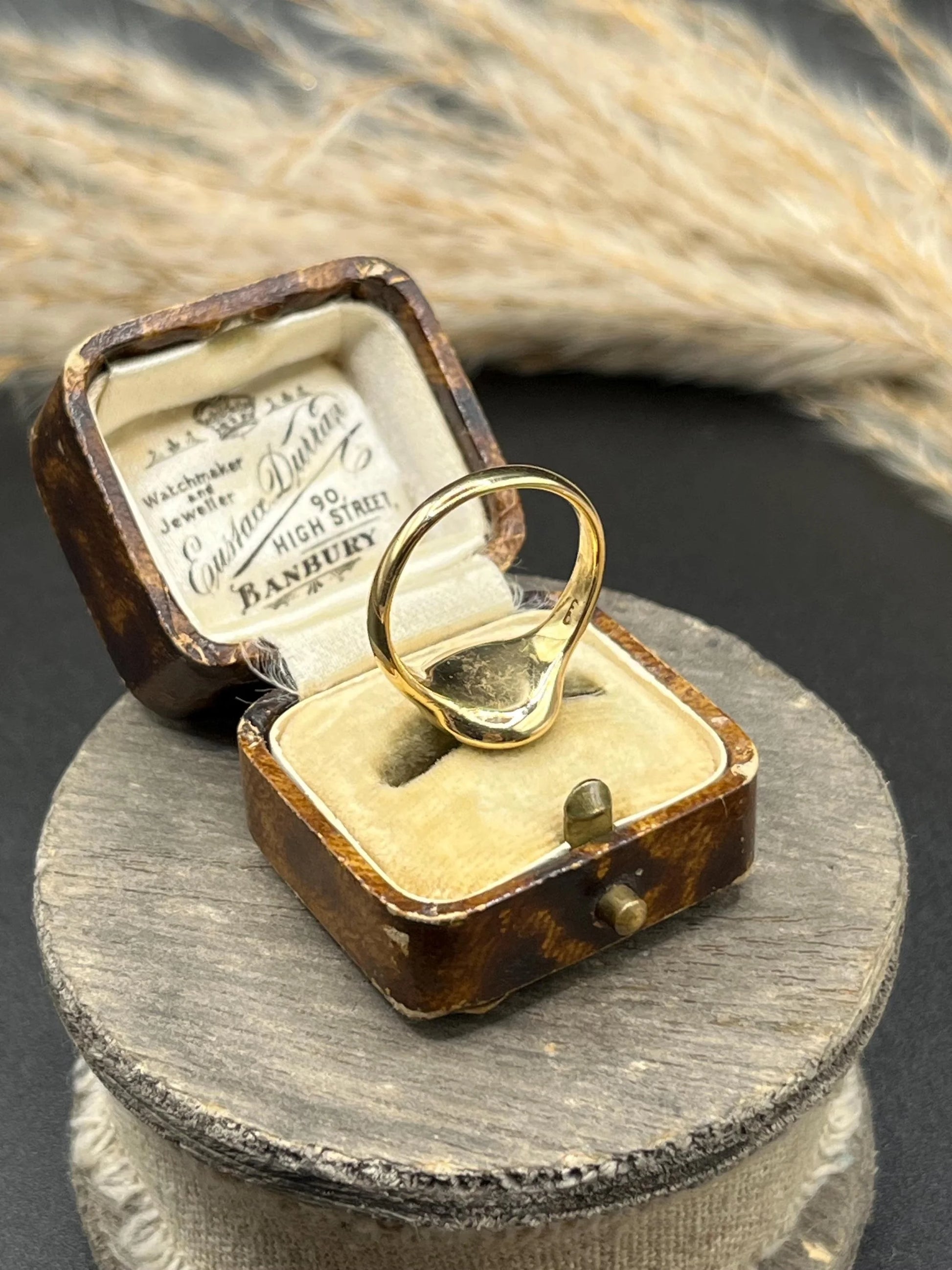 A yellow gold plain oval signet ring, in a ring box