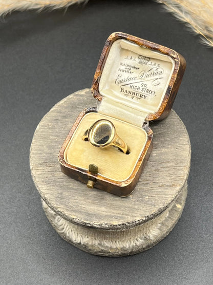 A yellow gold plain oval signet ring, in a ring box