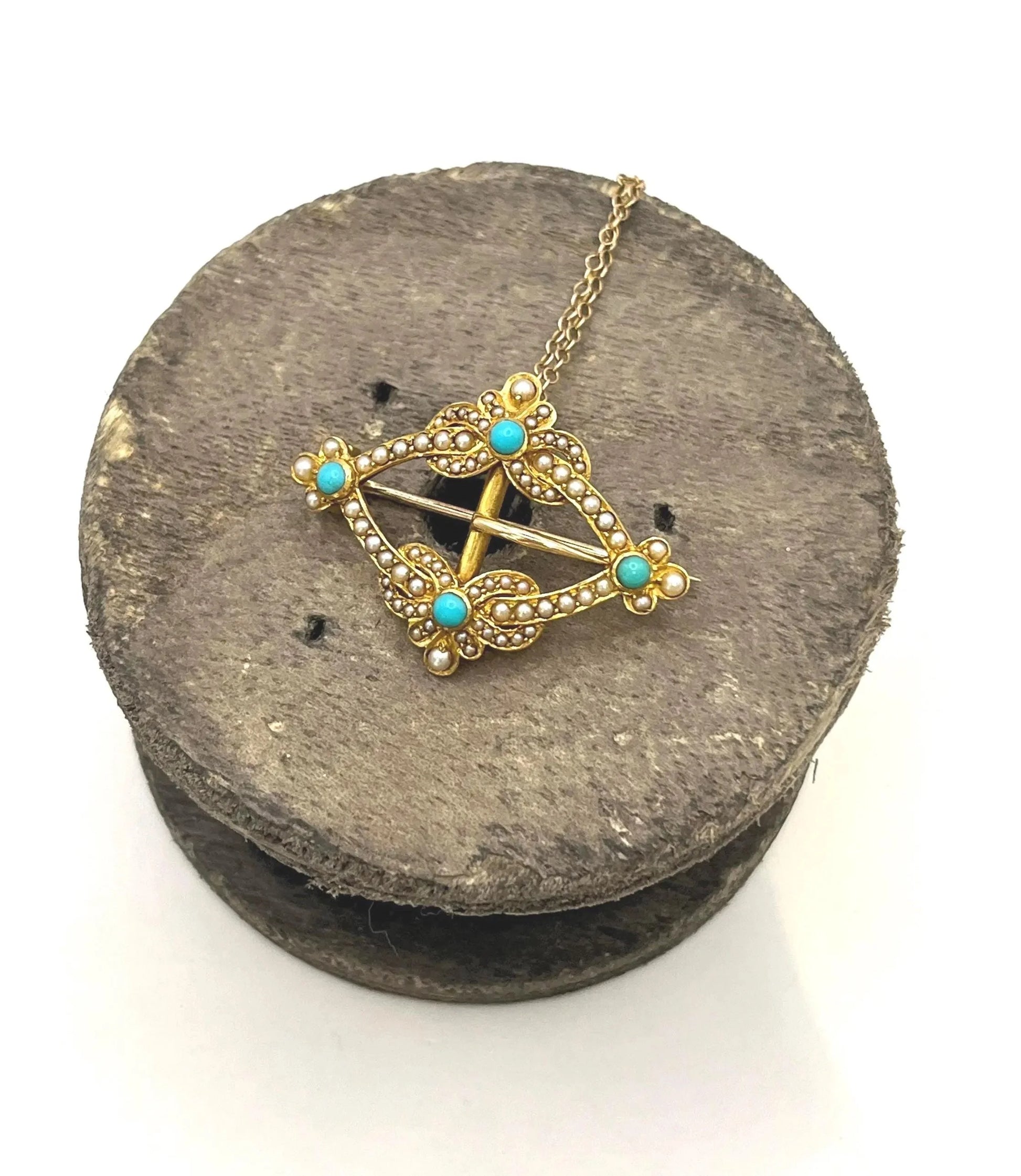 A yellow gold buckle style brooch/pendant with turquoise and seed pearls, with a chain